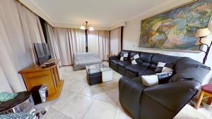 a living room with a couch and a tv at Altos de San Alfonso in Algarrobo