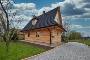 Cabaña de madera pequeña con techo negro en Chochołóvka, en Chochołów