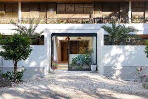 eine Eingangstür eines weißen Hauses mit Pflanzen in der Unterkunft Silvestre Nosara Hotel & Residences in Nosara