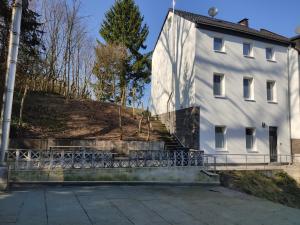 ein weißes Gebäude mit einer Treppe davor in der Unterkunft Neu Eröffnet, Wuppertal Villa in Wuppertal
