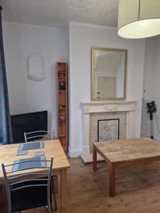 a living room with a table and chairs and a fireplace at Suite 3: Homely Room near Sheffield CC in Sheffield