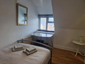 una camera da letto con un letto e due asciugamani di Suite 3: Homely Room near Sheffield CC a Sheffield