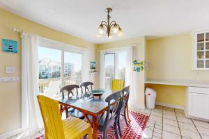 uma sala de jantar com uma mesa e cadeiras e uma janela em Mystic Heights em Emerald Isle