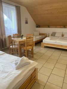 Habitación con 2 camas, mesa y sillas en Penzion Pod pecí, en Lenora
