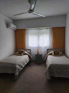 1 dormitorio con 2 camas y ventana en Hotel Americana, en Punta del Este