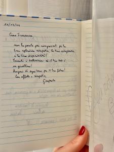 una persona ha in mano un quaderno con la calligrafia di FUTURA ROOM&RELAX a Termoli