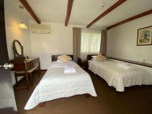 Habitación de hotel con 2 camas y escritorio en HOTEL & SPA LAGUNA SECA, en Los Baños del Inca