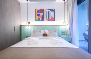 Elite LUX Holiday Homes - Elegant 2BR Suite in Business Bay Dubai في دبي: غرفة نوم بها سرير كبير مع مناشف عليه +13 صورة