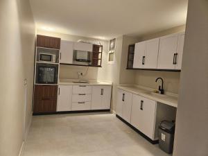 A kitchen or kitchenette at شقة أنيقة مودرن بدخول ذكي و سطح بجلسة خارجية