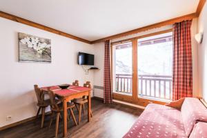 a living room with a table and a couch at Résidence Les Valmonts - maeva Home - Appartement 2 Pièces 4 Personnes - Sélection MAE-1036 in Saint-Martin-de-Belleville