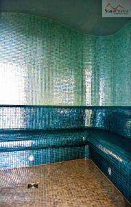 bagno con parete verde piastrellata e panca di Apartamenty Stara Polana a Zakopane