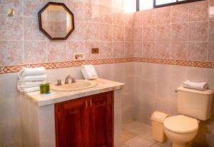 a bathroom with a sink and a toilet and a mirror at Hotel Oblitas in Cochabamba