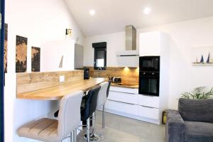 une cuisine avec des placards blancs et un comptoir en bois dans l'établissement 36 2 L'air marin maison duplex grande terrasse, à Narbonne