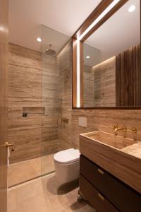 a bathroom with a toilet and a sink and a mirror at Silvestre Nosara Hotel & Residences in Nosara