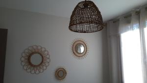 Habitación con 2 espejos y una lámpara de araña en la pared. en Appartement à la campagne, en Aiglun
