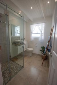 Un baño con ducha de cristal y un inodoro. en Beach Haven, en Ciudad del Cabo