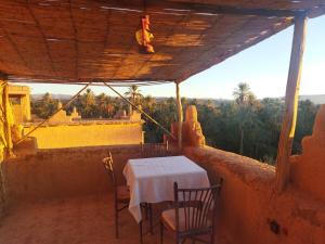 una mesa y sillas en el balcón de una casa en Auberge et Restaurant chez Alilouch, en Nkob