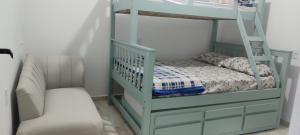 a bunk bed with a ladder and a chair in a room at Vitoria Hostel in Guarulhos