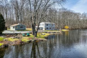 a house and a house on the shore of a river at Charming Deep River Vacation Rental on Star Lake! in Deep River