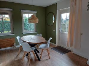 a dining room with a table and white chairs at Natuur Appartement Dinxperlo in Dinxperlo