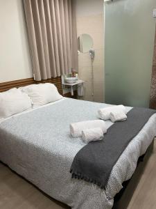 a bedroom with a bed with two towels on it at Saboresgelados Alojamento Local in Braga