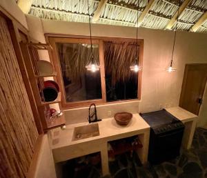 a kitchen with a sink and a window and lights at Madre Selva in San Pedro Pochutla