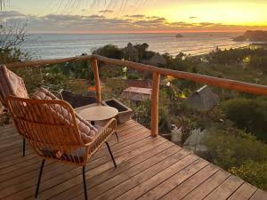 a deck with two chairs and a view of the ocean at Madre Selva in San Pedro Pochutla