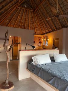 a bedroom with a bed and a wooden ceiling at Madre Selva in San Pedro Pochutla
