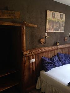 1 dormitorio con 1 cama con almohadas azules en Locanda Al Cacciatore, en Seren del Grappa