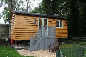 a small wooden cabin with a staircase in a yard at The Apple Inn in Lucker