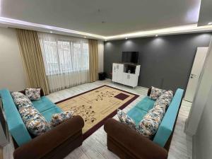uma sala de estar com sofás e uma mesa num quarto em 140 m2 Size Ait em Çayirhisar