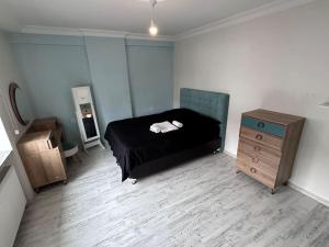 1 dormitorio con cama negra y tocador de madera en My Shelter Balıkesir, en Çayirhisar