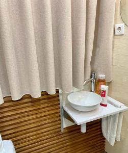 a bathroom with a sink and a shower curtain at Saboresgelados Alojamento Local in Braga