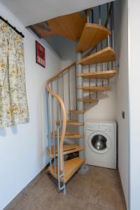 a wooden spiral staircase next to a washing machine at LOFT OLIMPICO TORINO in Turin