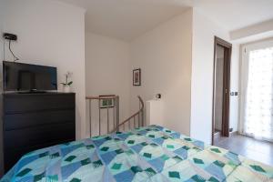 LOFT OLIMPICO TORINO في تورينو: غرفة نوم بسرير وتلفزيون بشاشة مسطحة