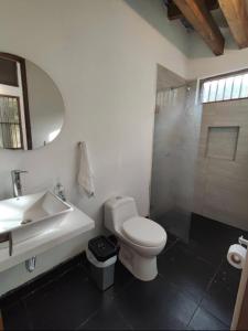 a bathroom with a sink and a toilet and a mirror at Cabaña Pazatiempo II Sapzurro in Sapzurro