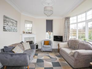 a living room with two couches and a fireplace at Casita in Benllech