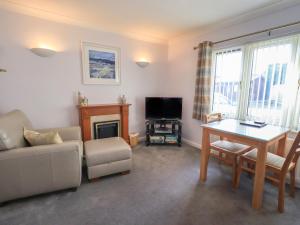 a living room with a couch and a table and a television at Troutbeck in Ambleside