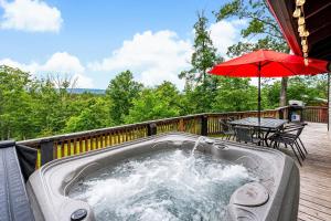 a hot tub on a deck with an umbrella at Modern Cabin w Mountain View Hot Tub & Fire Pit in Morton Grove