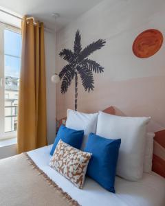 a bedroom with a bed with blue and white pillows at "Le Majorelle" logement atypique en hyper centre, avec service premium by PRIMO C0NCIERGERIE in Nevers