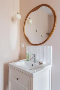 La salle de bains est pourvue d'un lavabo blanc et d'un miroir. dans l'établissement "Le Majorelle" logement atypique en hyper centre, avec service premium by PRIMO C0NCIERGERIE, à Nevers