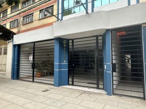 una tienda con puertas de garaje azules y negras en Hotel Oblitas, en Cochabamba