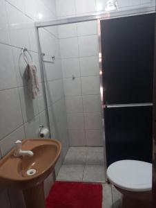 a bathroom with a shower with a toilet and a sink at Hosthê compartilhados in Canoas
