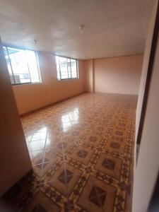 Habitación vacía con suelo de baldosa y 2 ventanas en departamento en Quito