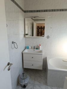 a white bathroom with a sink and a mirror at Medjugorje Perfect family house in Međugorje