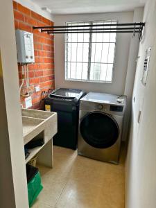 lavadero con lavadora y ventana en Maravilloso alojamiento para tu familia en Santa Rosa de Cabal