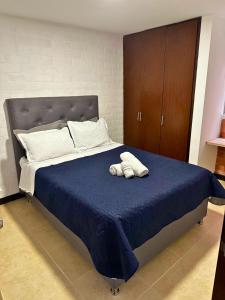 1 cama con edredón azul y toalla en Maravilloso alojamiento para tu familia en Santa Rosa de Cabal