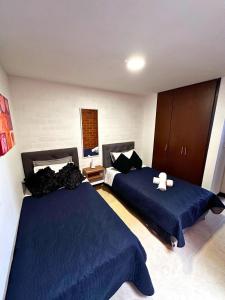 1 dormitorio con 2 camas y sábanas azules en Maravilloso alojamiento para tu familia en Santa Rosa de Cabal