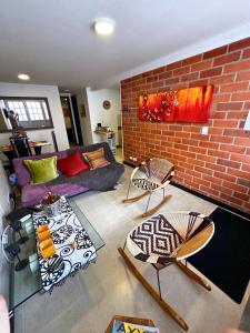 sala de estar con sofá y pared de ladrillo en Maravilloso alojamiento para tu familia, en Santa Rosa de Cabal