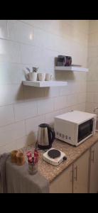 um balcão de cozinha com uma torradeira e um micro-ondas em شقة بصالة مودرن وغرفة نوم em Buraydah
